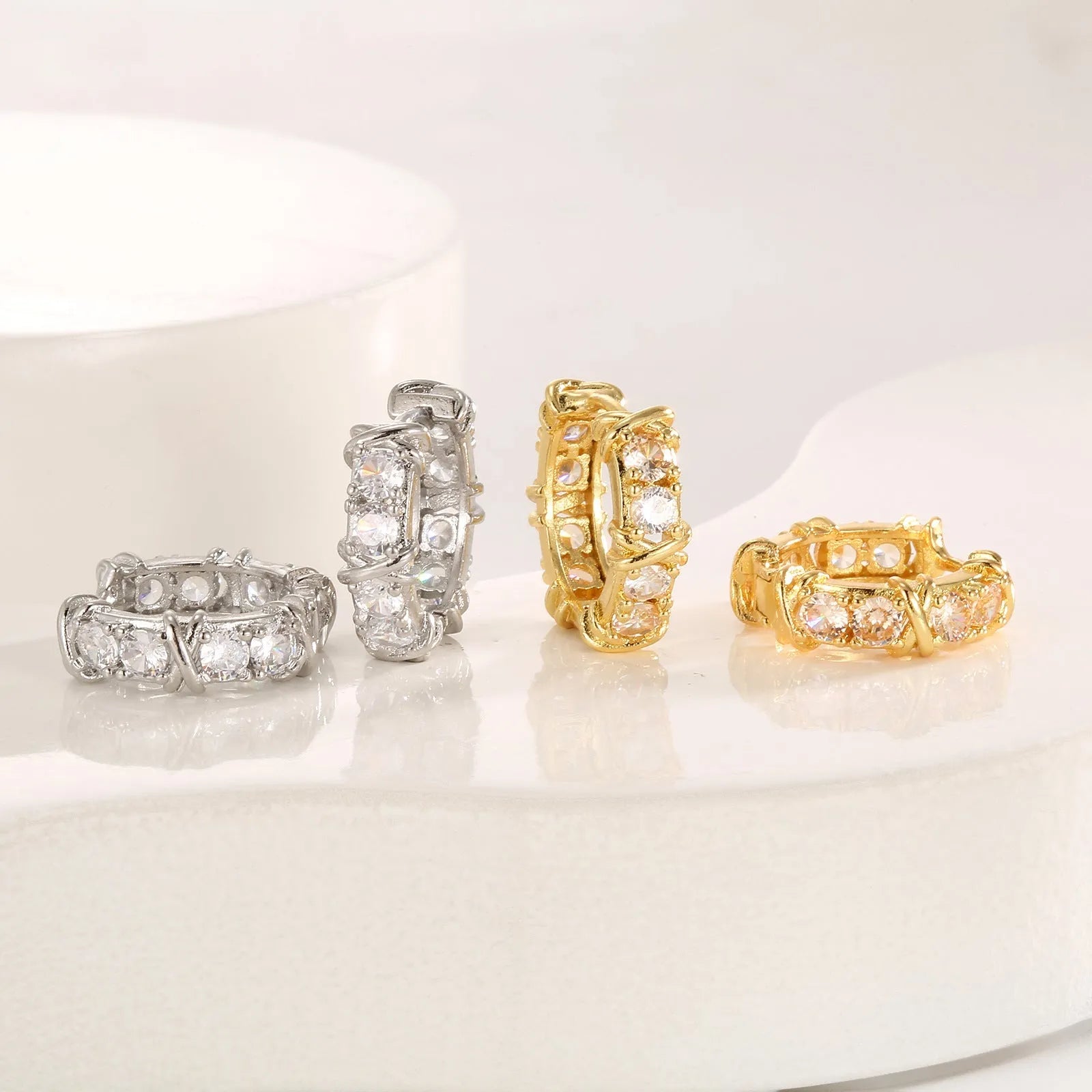 Geometric hexagonal clover cross shape earrings with ellipse detail, shown in gold and silver electroplated colours.