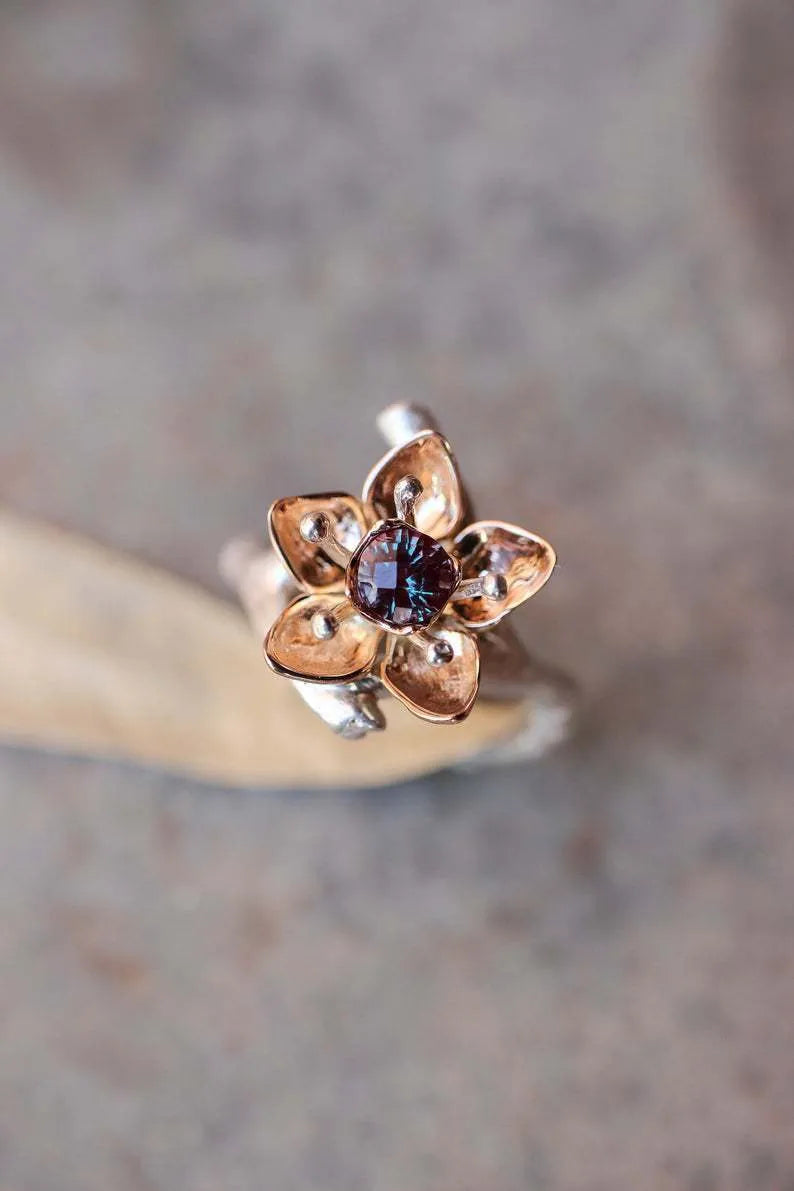Silver two-tone women's ring with a geometric shape and floral design on a grey background