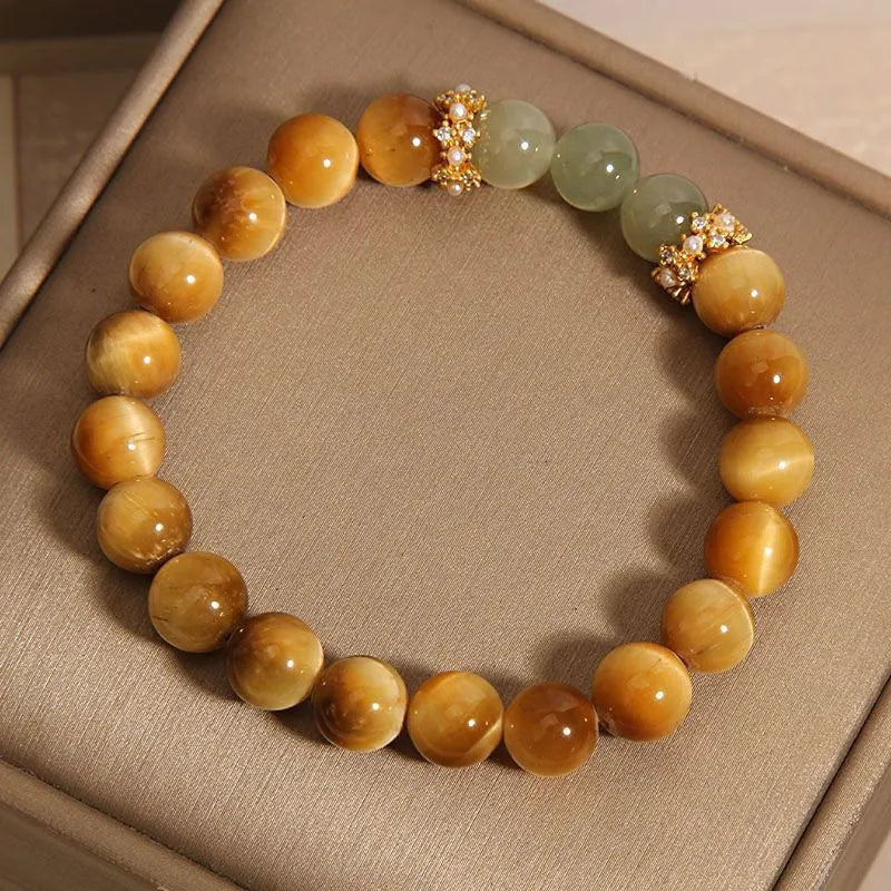 Natural yellow tiger's eye Hetian jade bracelet with diamond polish and auspicious pattern on white background