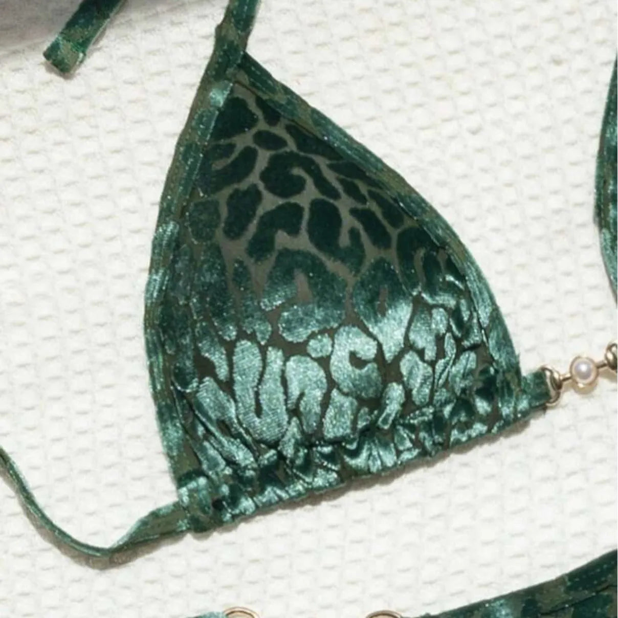 Women's blue leopard print bikini set on a yellow background, showing triangle top and briefs style.