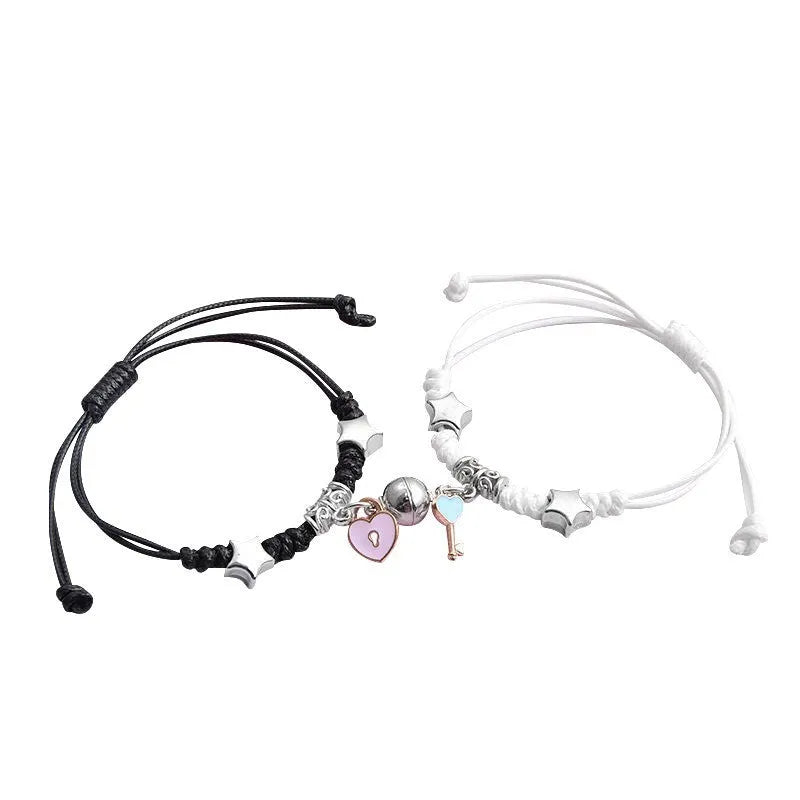A pair of silver alloy bracelets with magnetic clasps and assorted charm designs including crowns, stars, and clovers.