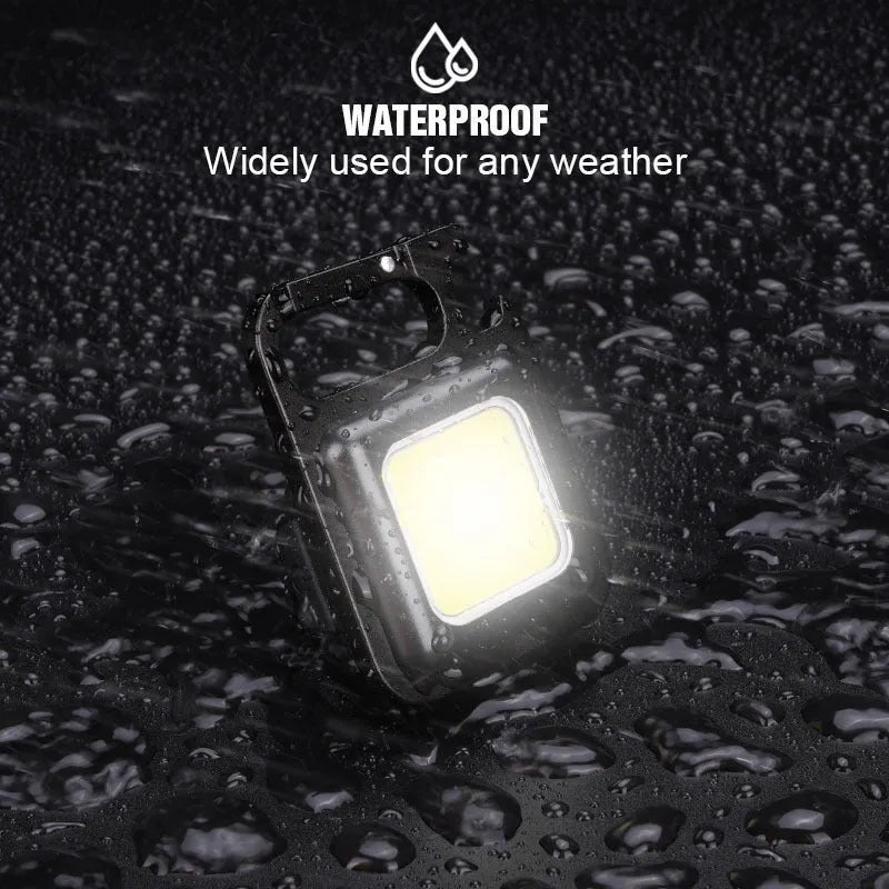 Black aluminium alloy keychain light with COB LED, magnetic base, and foldable handle on keyring