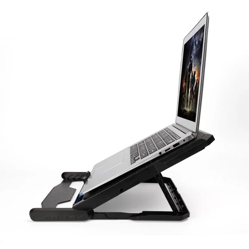 Black metal mesh laptop cooling board with USB cable on a desk next to a notebook.