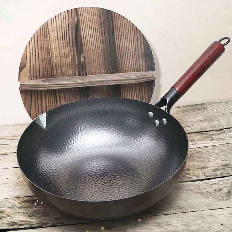 Traditional handmade iron wok pan with wooden handle and black finish