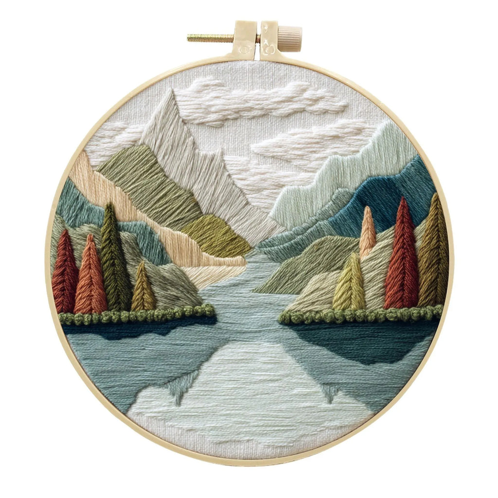 Embroidery DIY landscape kit with cotton fabric, bamboo frame, threads, and needles for handmade cloth art.