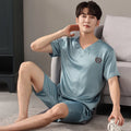 Man wearing a light blue short-sleeve ice silk pajama top and matching loose shorts.