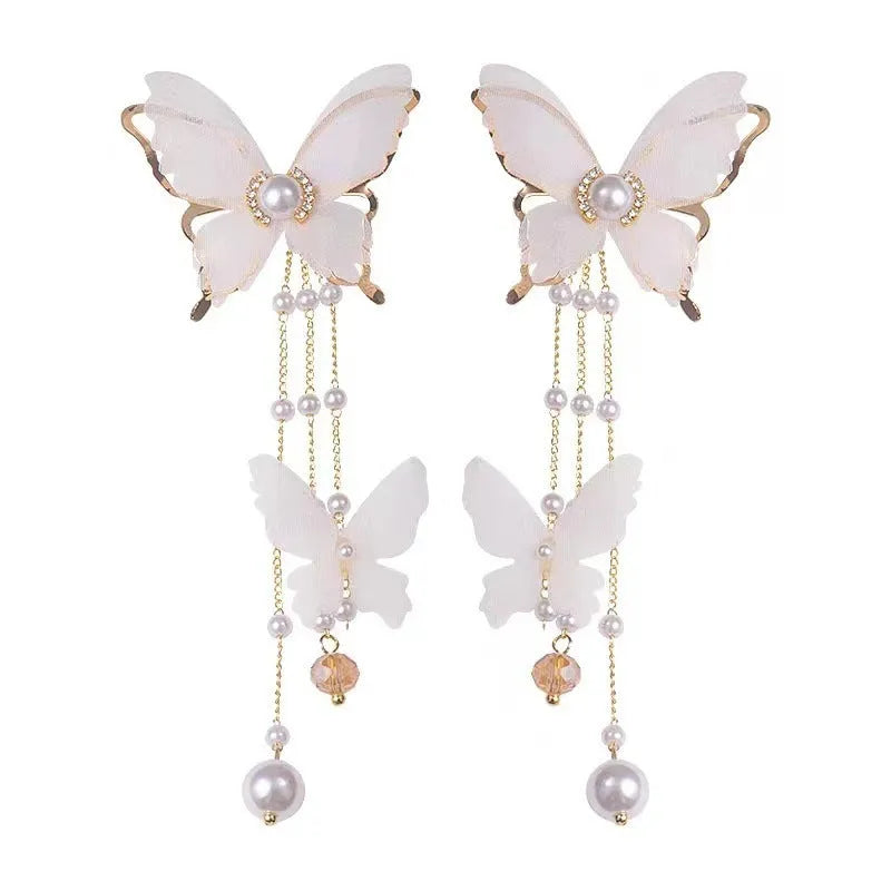 White butterfly-shaped earrings with tassel design featuring lace patterns, pearls, and rhinestones