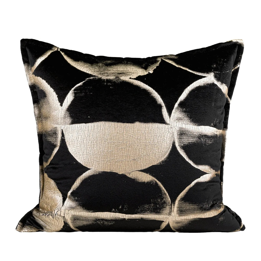 Black gold abstract patterned flannel decorative cushion on a sofa.