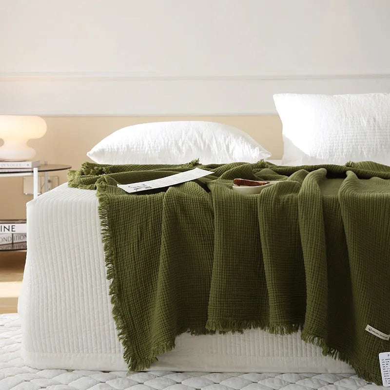 Cotton four-layer gauze throw blanket with tassel edges shown in avocado green colour.