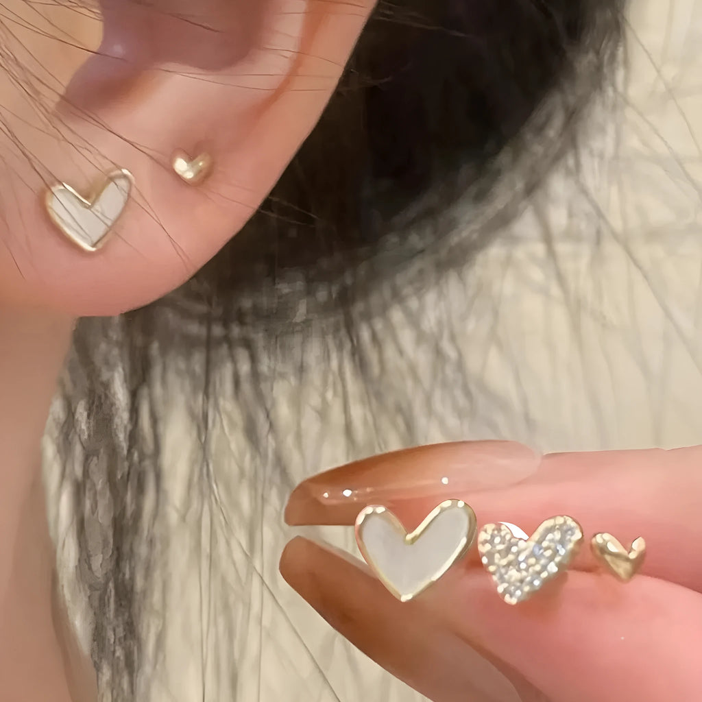 Three pairs of heart-shaped girly drop earrings in gold, black, pink colours