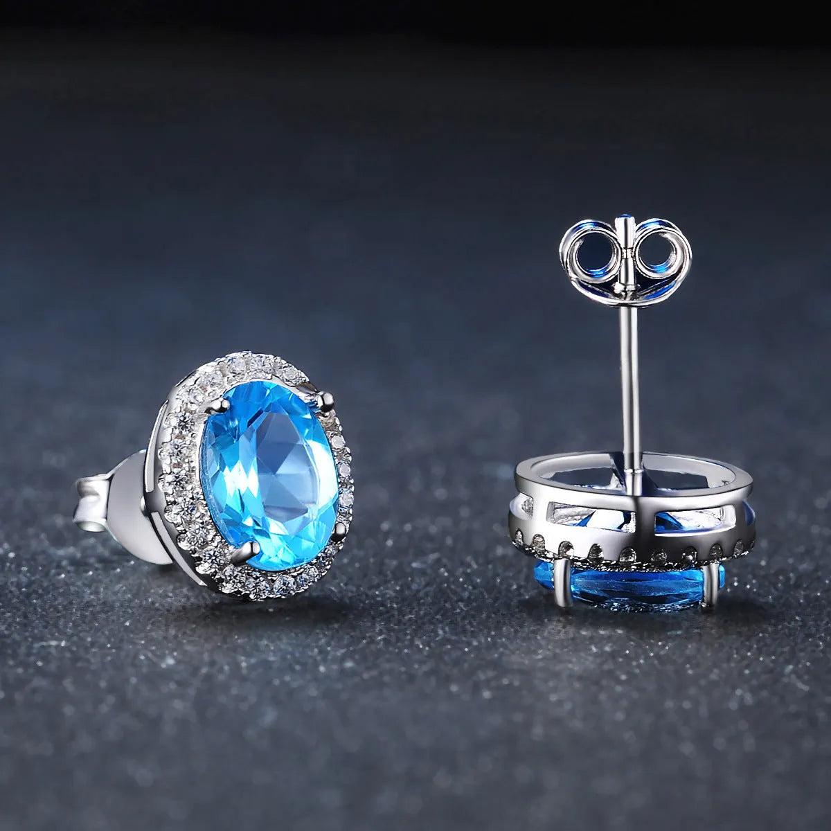 Women's sterling silver jewellery set with blue topaz gems featuring geometric earrings, ring, necklace and pendant