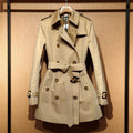 Khaki double-breasted trench coat for women with flight sleeves and button fastening.