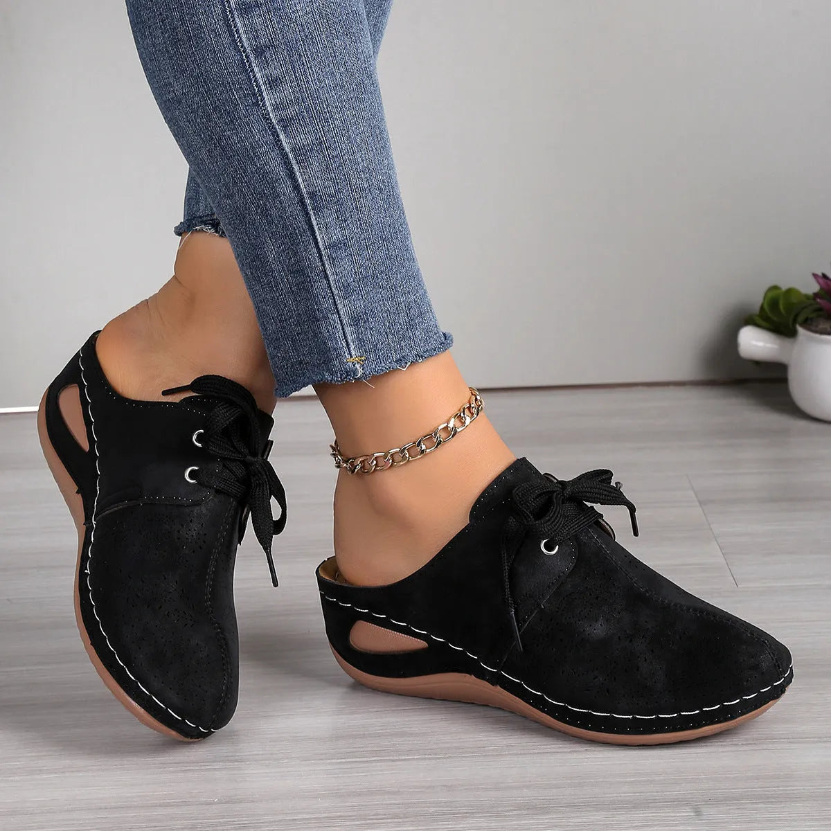 Women's black suede lace-up wedge slippers with a hollow out design and rubber sole.