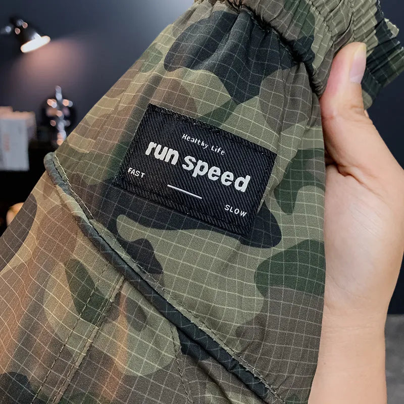Man wearing loose-fit camouflage cargo shorts made from a cotton blend fabric.