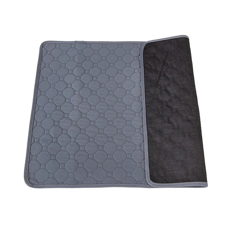 Two washable dog pee pads in grey and khaki on a floor, one with a small dog standing on it