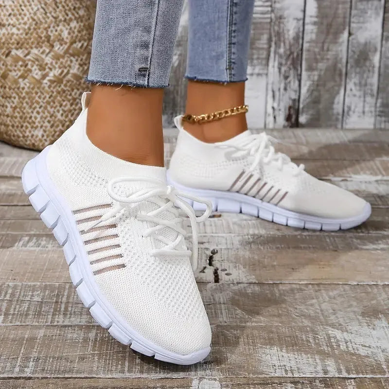 Casual ladies breathable flying knit sports flat shoes in black with mesh upper and front tie closure on foot