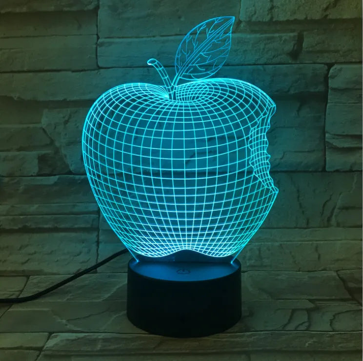 3D fruit-shaped night light with colourful LED glow and touch controls on a table.