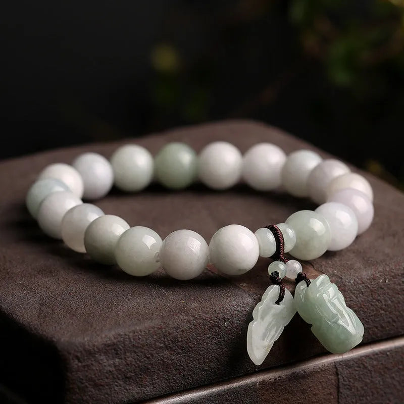 Natural emerald green jade hanging bracelet with Maitreya Buddha design on a geometric shape.