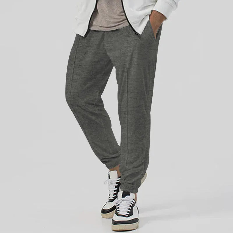 Men's grey cotton blend track sweatpants with elastic waistband and straight-leg tapered design