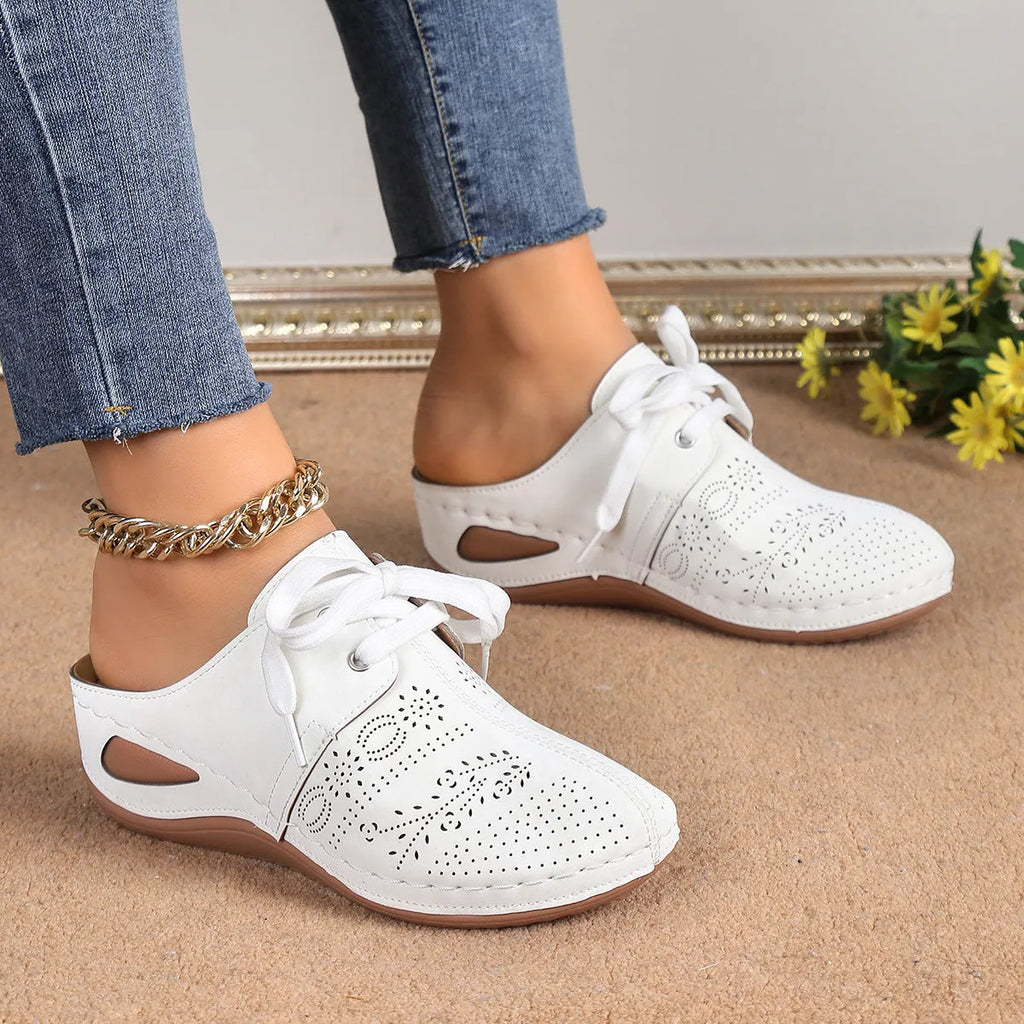 Women's black suede lace-up wedge slippers with a hollow out design and rubber sole.