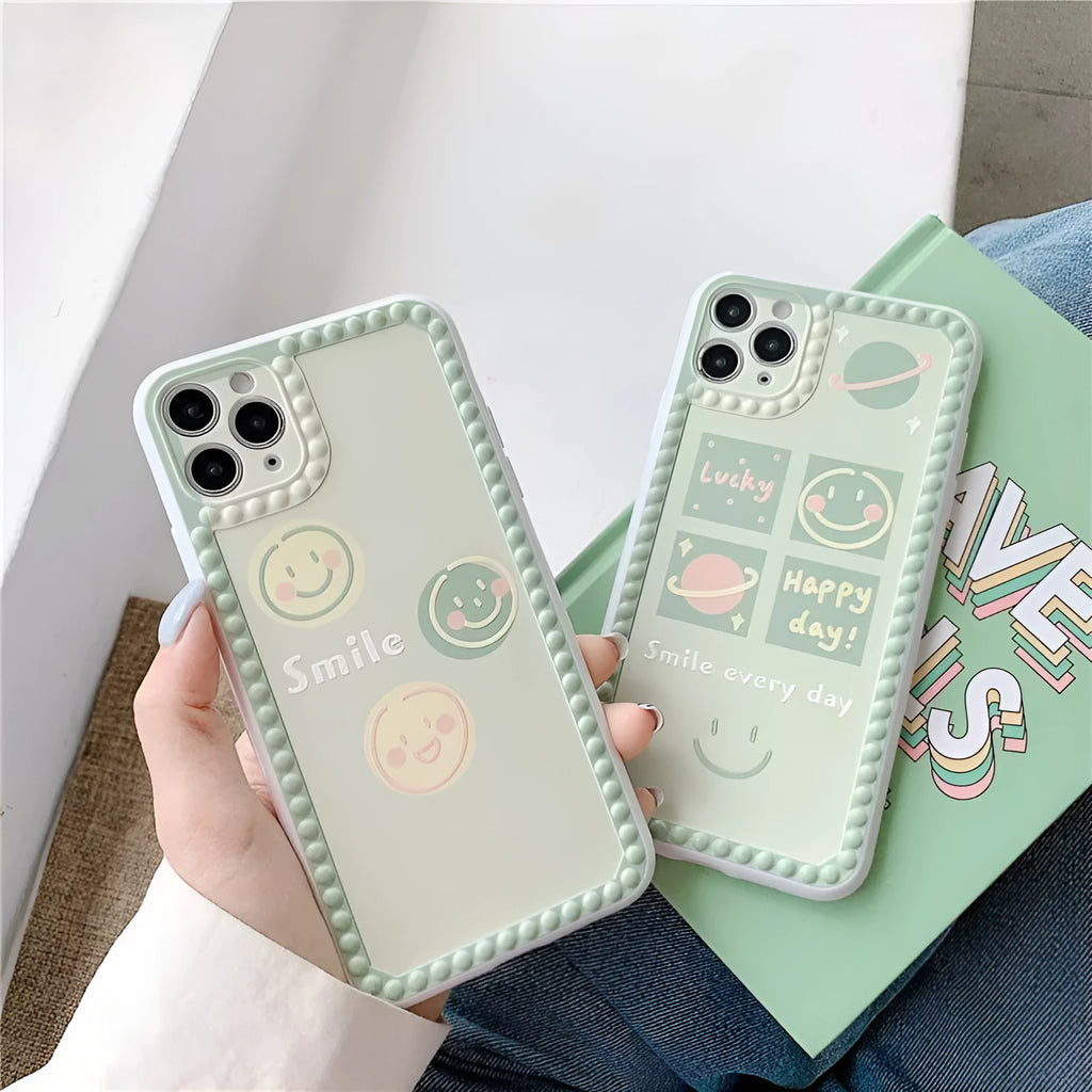 Green flexible TPU iPhone case with geometric smiley face and polka dot frame design.