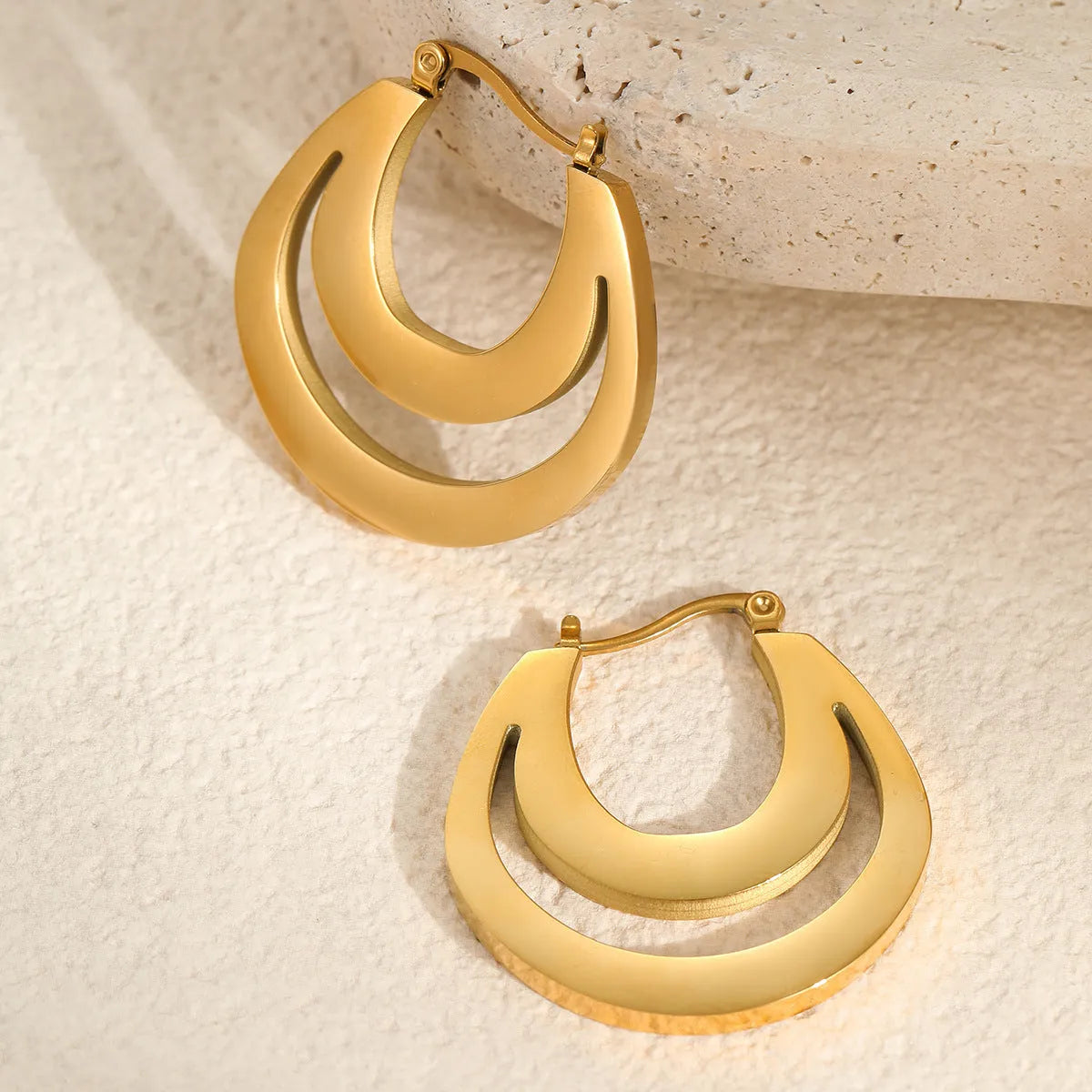 Geometric French earrings with 18K gold plating on stainless steel, featuring round ring elements in minimalist design
