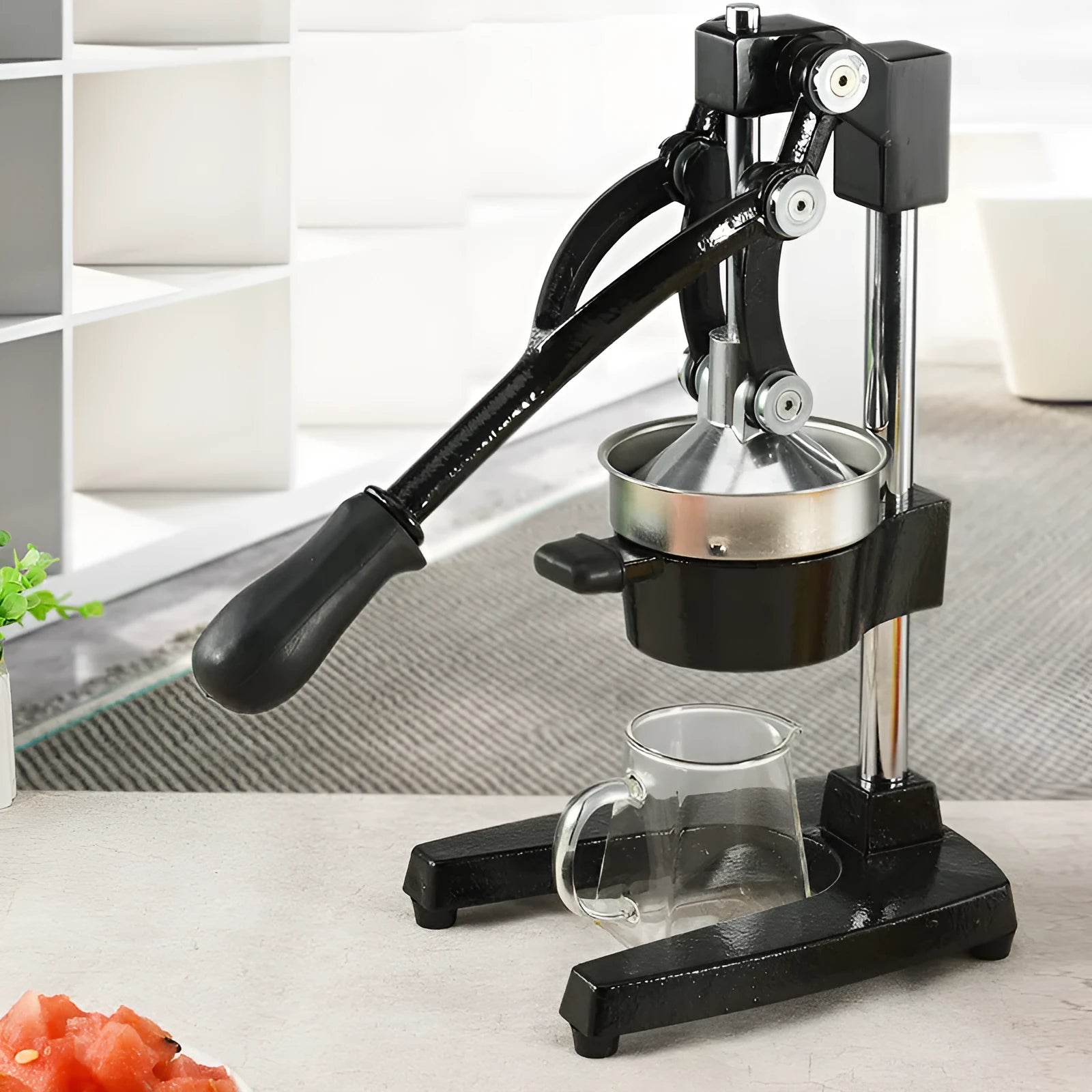 Cast iron manual citrus juicer with stainless steel funnel showing black finish