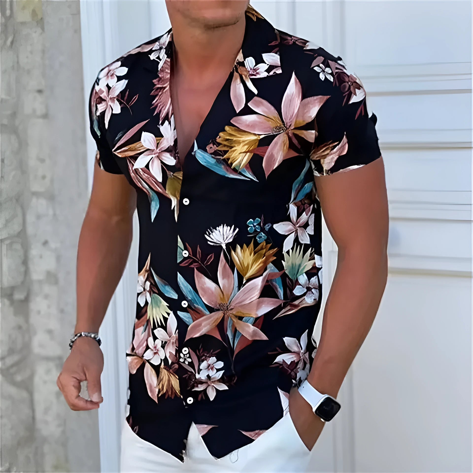 Man wearing a loose-fit short sleeve shirt with a colourful floral print pattern.
