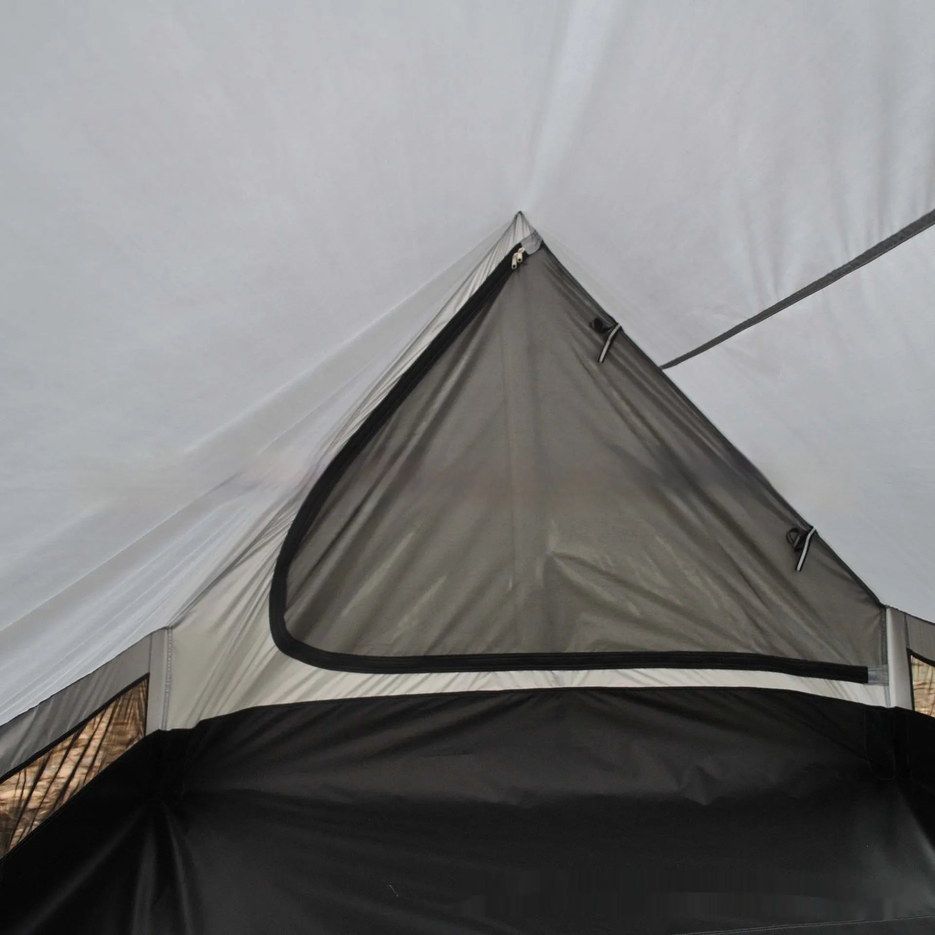 Brown A-frame hiking tent supported by hiking poles showing spacious interior for 2-3 campers