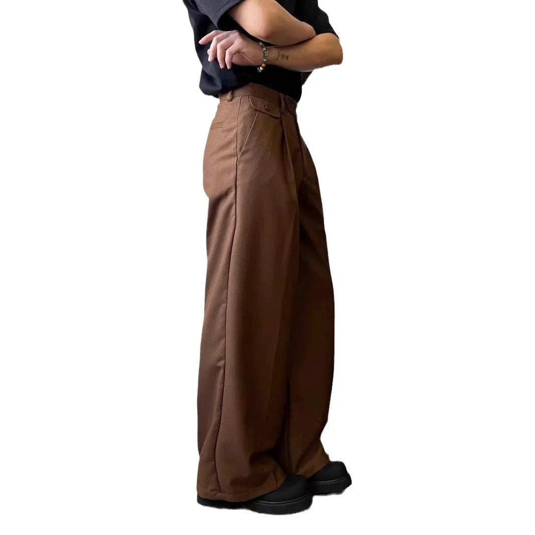 Men's brown straight-leg casual suit trousers with a loose, wide-leg fit on a hanger.