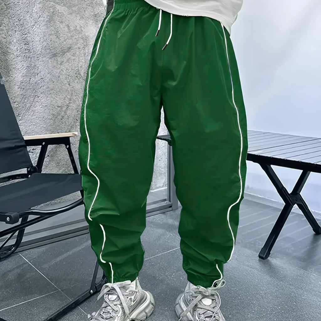 Man wearing loose-fit, cropped-length bamboo fibre sports trousers in a neutral colour.