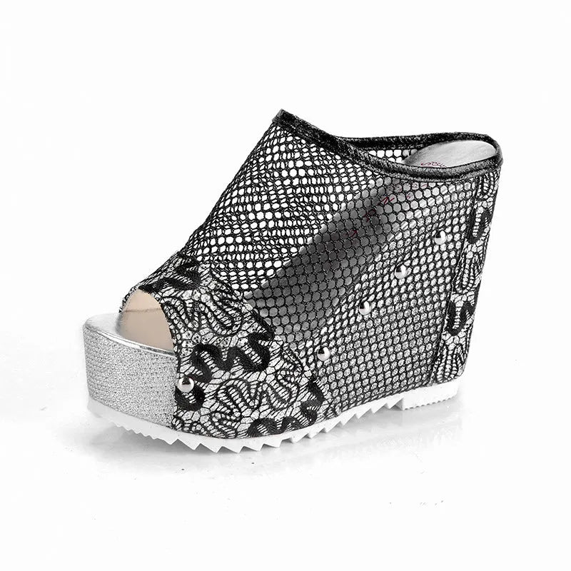 Black platform flip-flops with a chunky heel, hollowed-out design, and mesh upper on a white background.