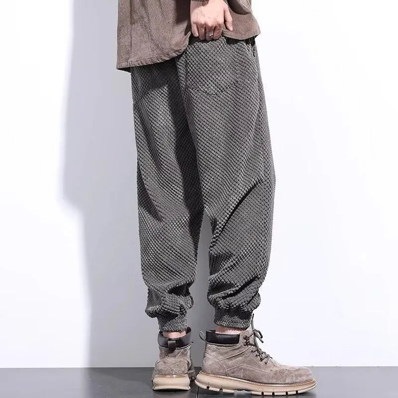 Grey men's straight-leg sweatpants with ankle ties laid flat.