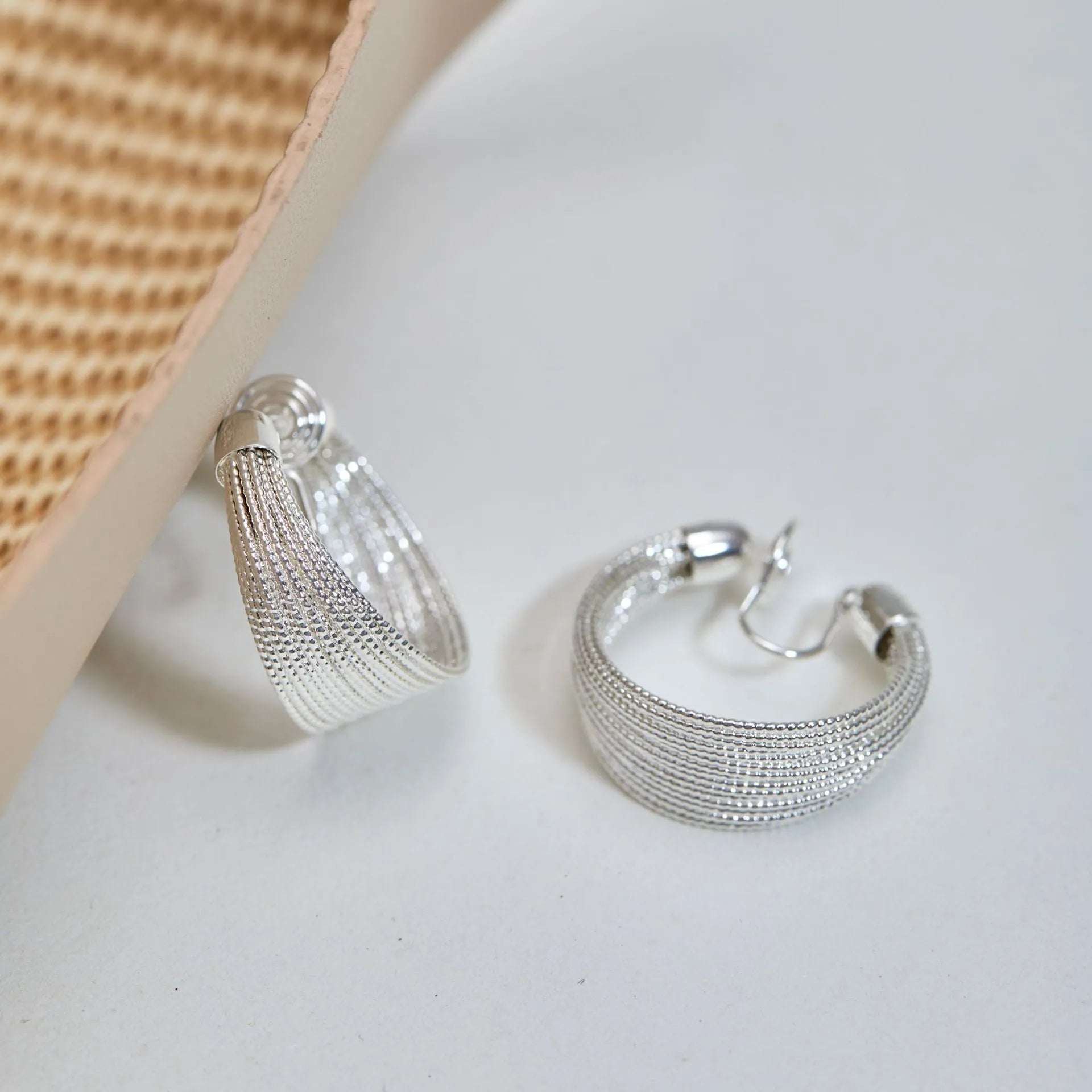 Geometric multi-layer copper earrings with an electroplated silver or gold finish, shown as studs and clips.