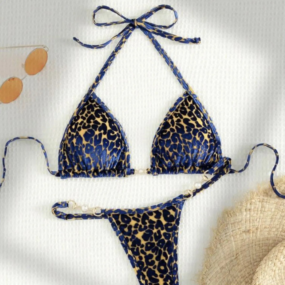 Women's blue leopard print bikini set on a yellow background, showing triangle top and briefs style.