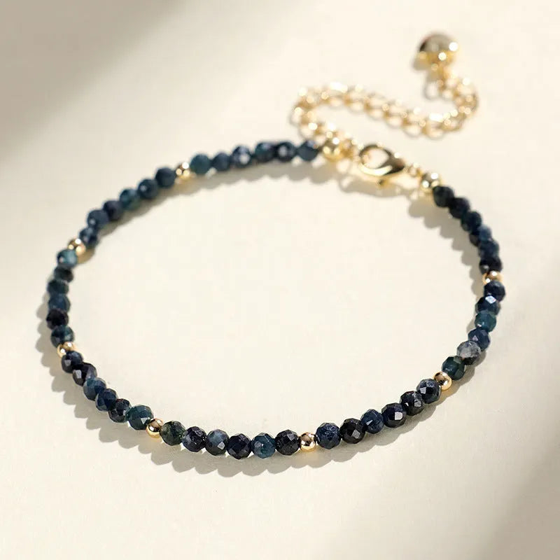 Close-up of a women's blue tourmaline bracelet with 3mm cut beads and spacer bead design.