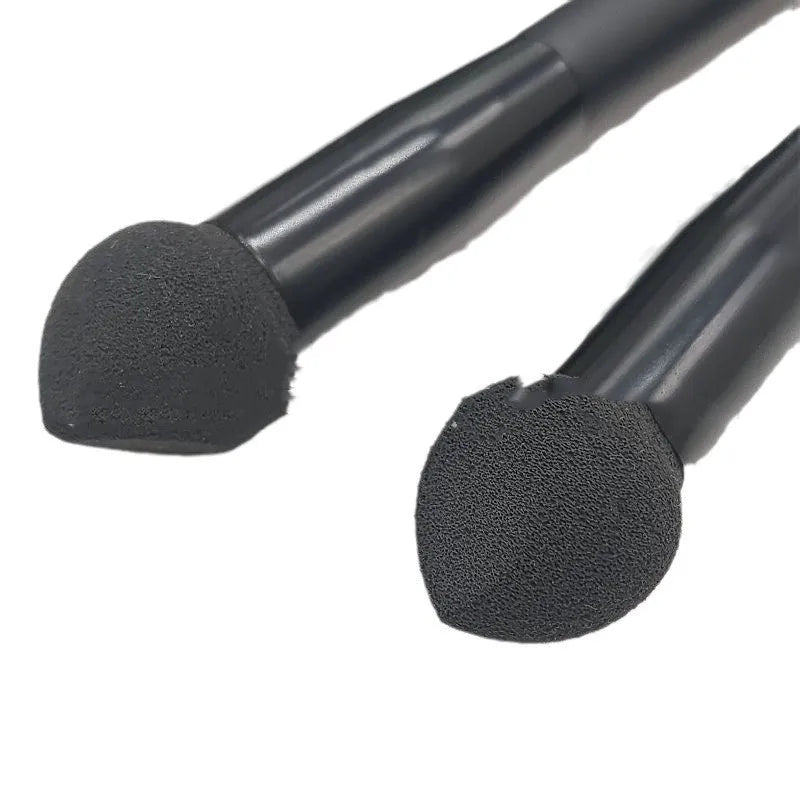 Black sponge stick concealer brush with wooden handle on white background