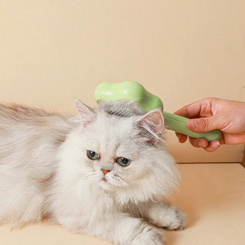 Green cat comb with stainless steel needles and self-cleaning magic wand function on white background