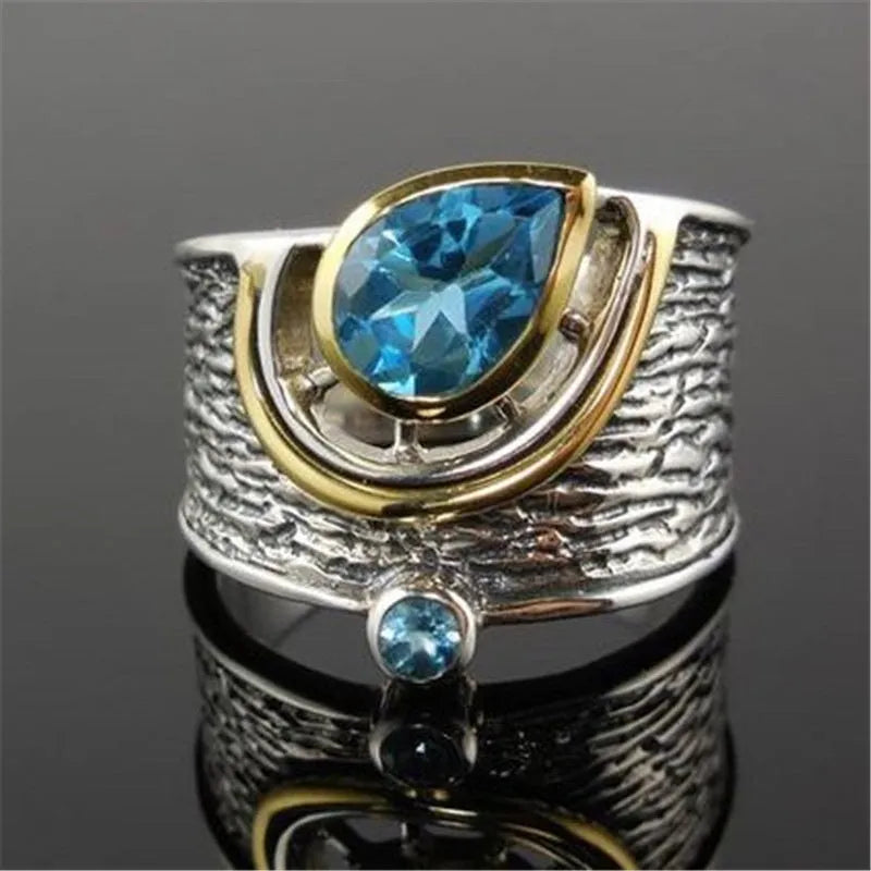 Blue rhinestone zircon drop shape ring on a white background, showing Chinese-inspired alloy design.