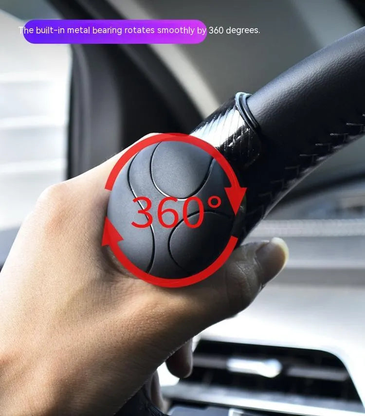 Black and blue steering wheel assist ball with silicone grip and metal bearing for single-handed steering.
