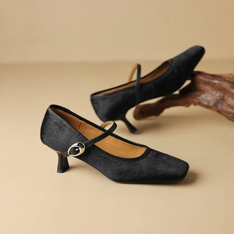 Women's black square toe stiletto ankle-strap heels with horse hair upper on a plain background.