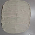 Beige portable baby nest cot cushion measuring 75cm by 45cm on a floor.