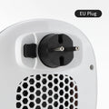 White ceramic electric heater with remote control on a table.