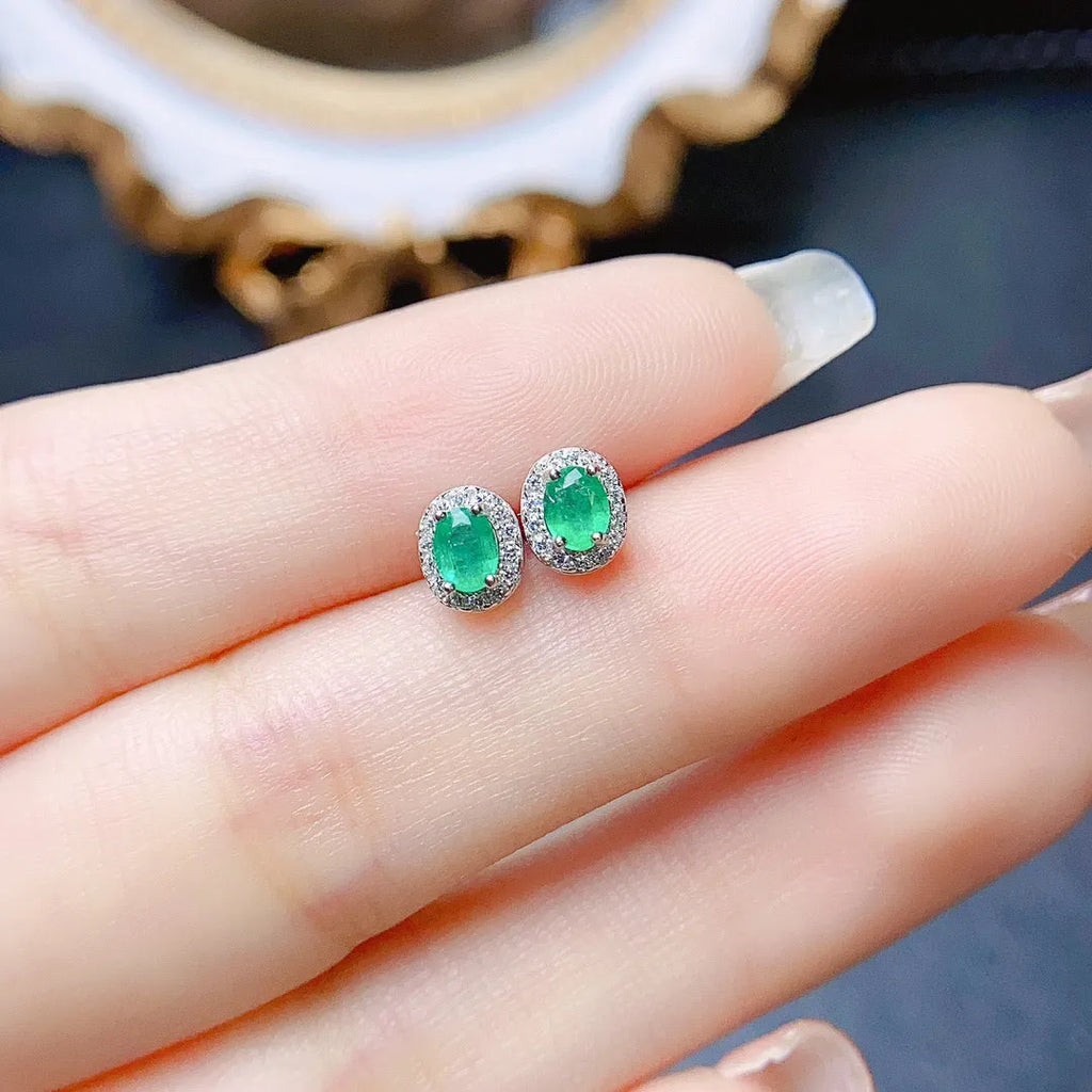 Natural emerald stud earrings in S925 silver with inlaid green main stone on white background