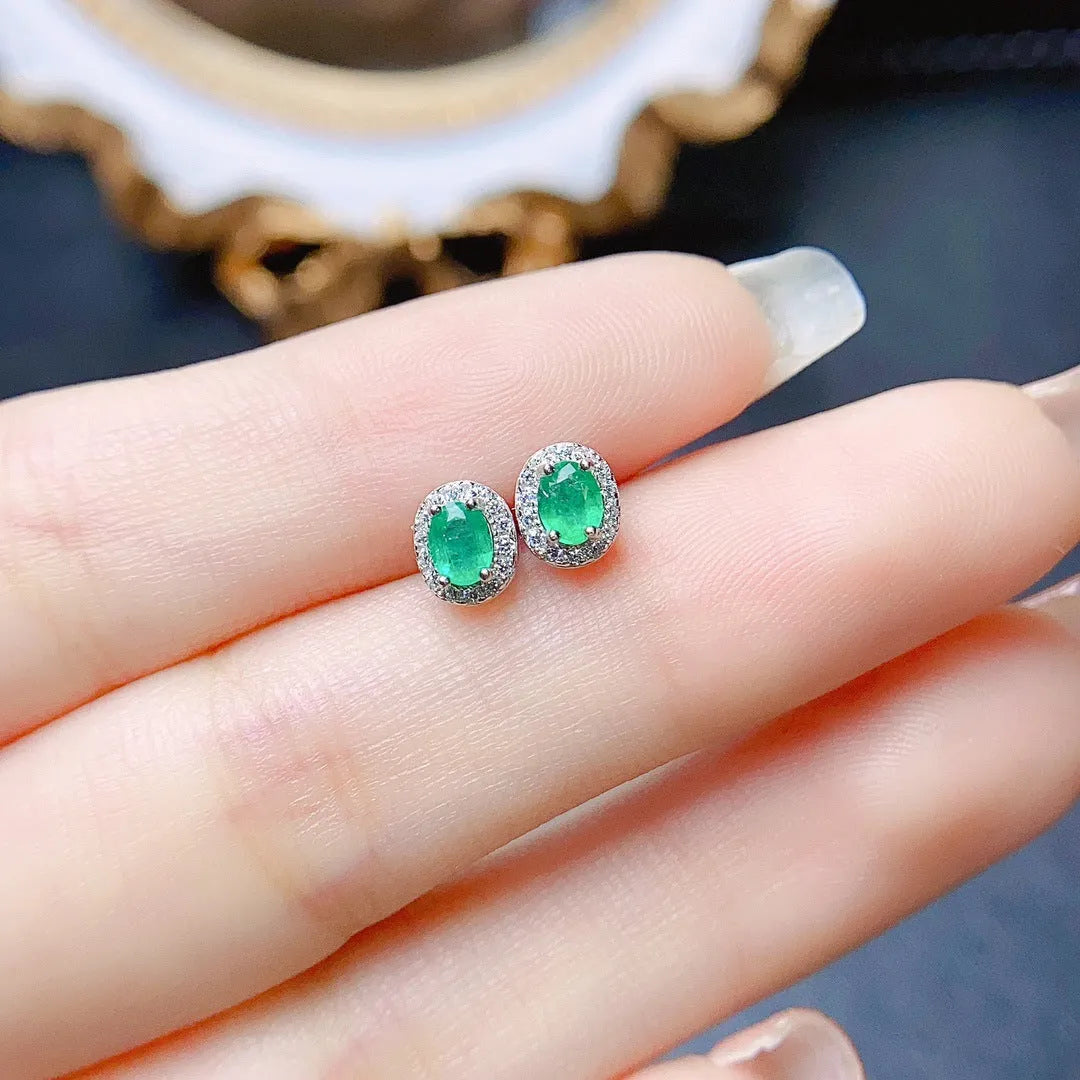 Natural emerald stud earrings in S925 silver with inlaid green main stone on white background