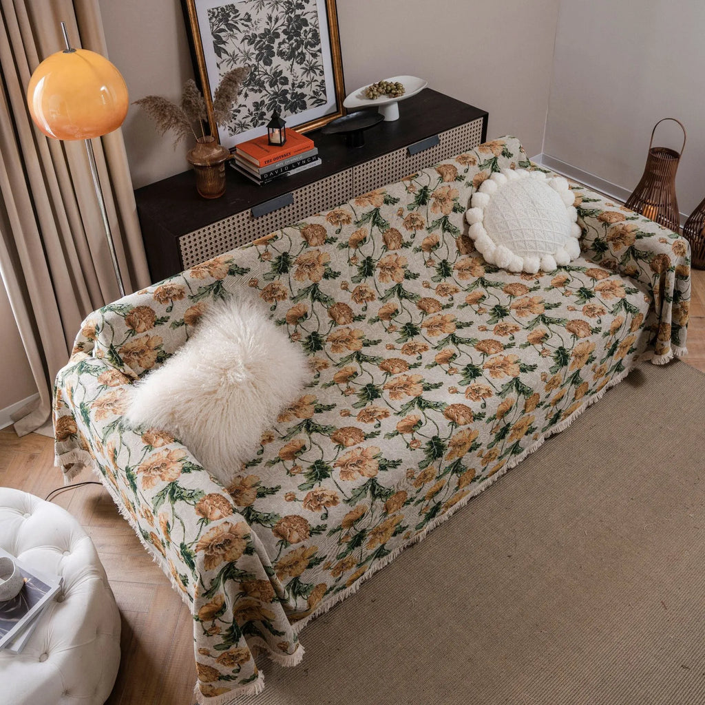 American country style jacquard patterned sofa cover in a green colourway draped over a sofa.