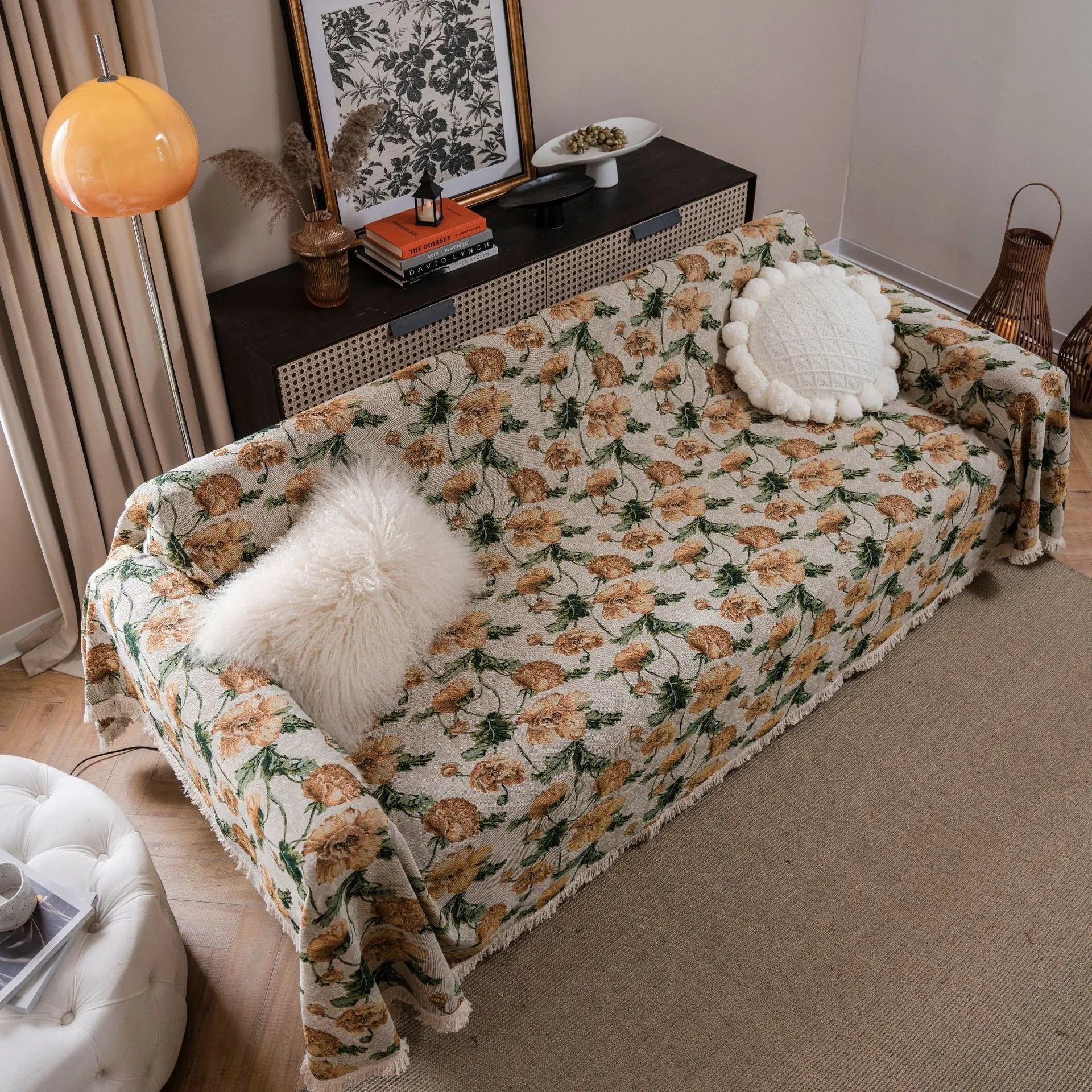 American country style jacquard patterned sofa cover in a green colourway draped over a sofa.
