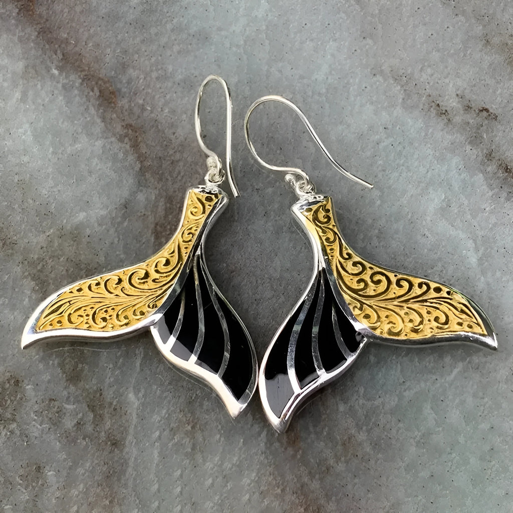 Close-up of women's retro fishtail earrings with a whale design in white gold colour.