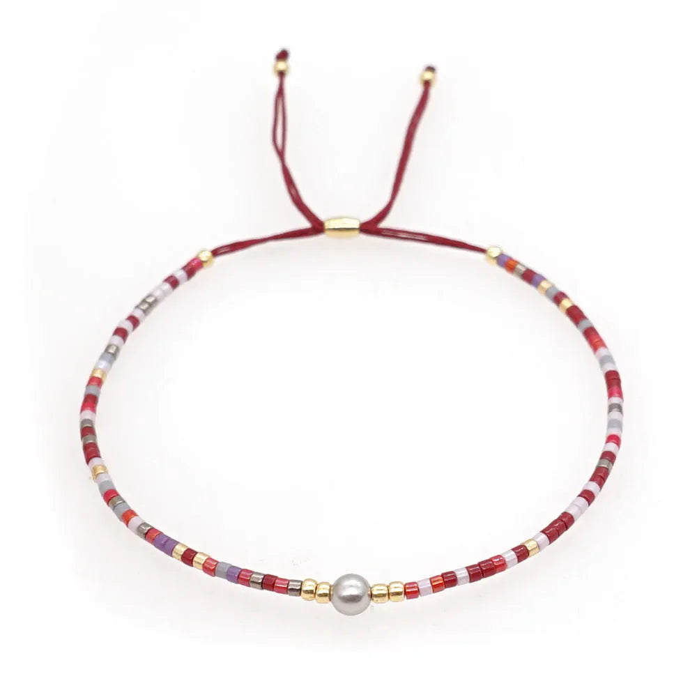 Handmade colourful glass beaded bracelet in geometric Bohemian style on a female wrist.
