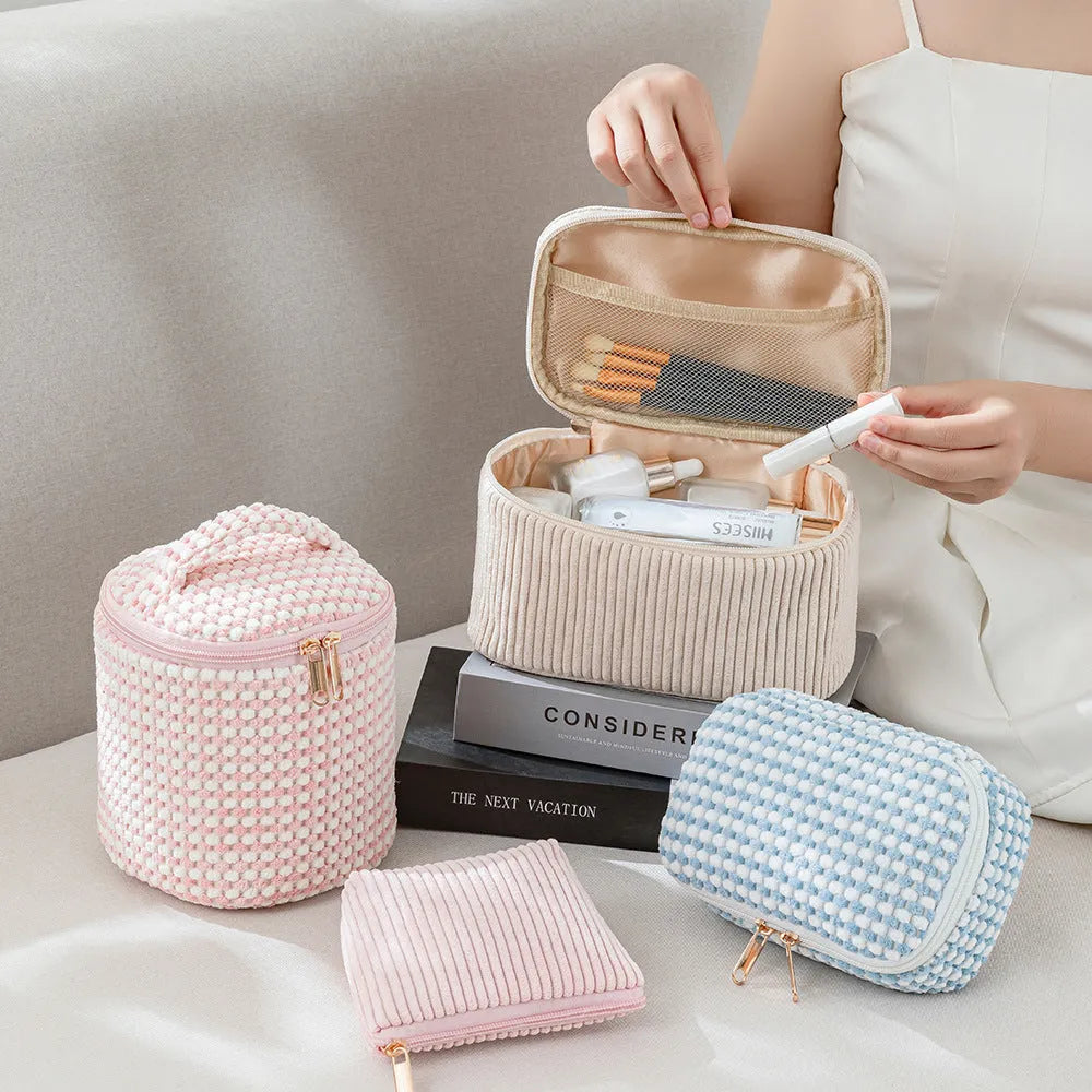 Four cube-shaped makeup bags in matching colour sets for travel cosmetic organisation